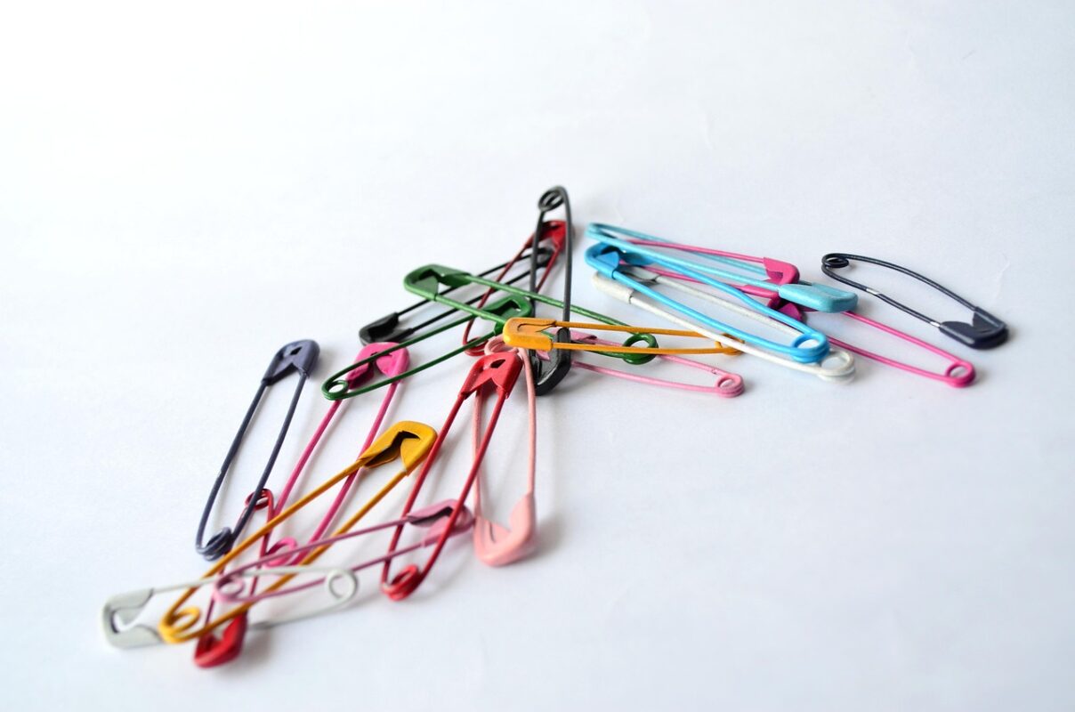 Straight pins with glass heads on a work surface